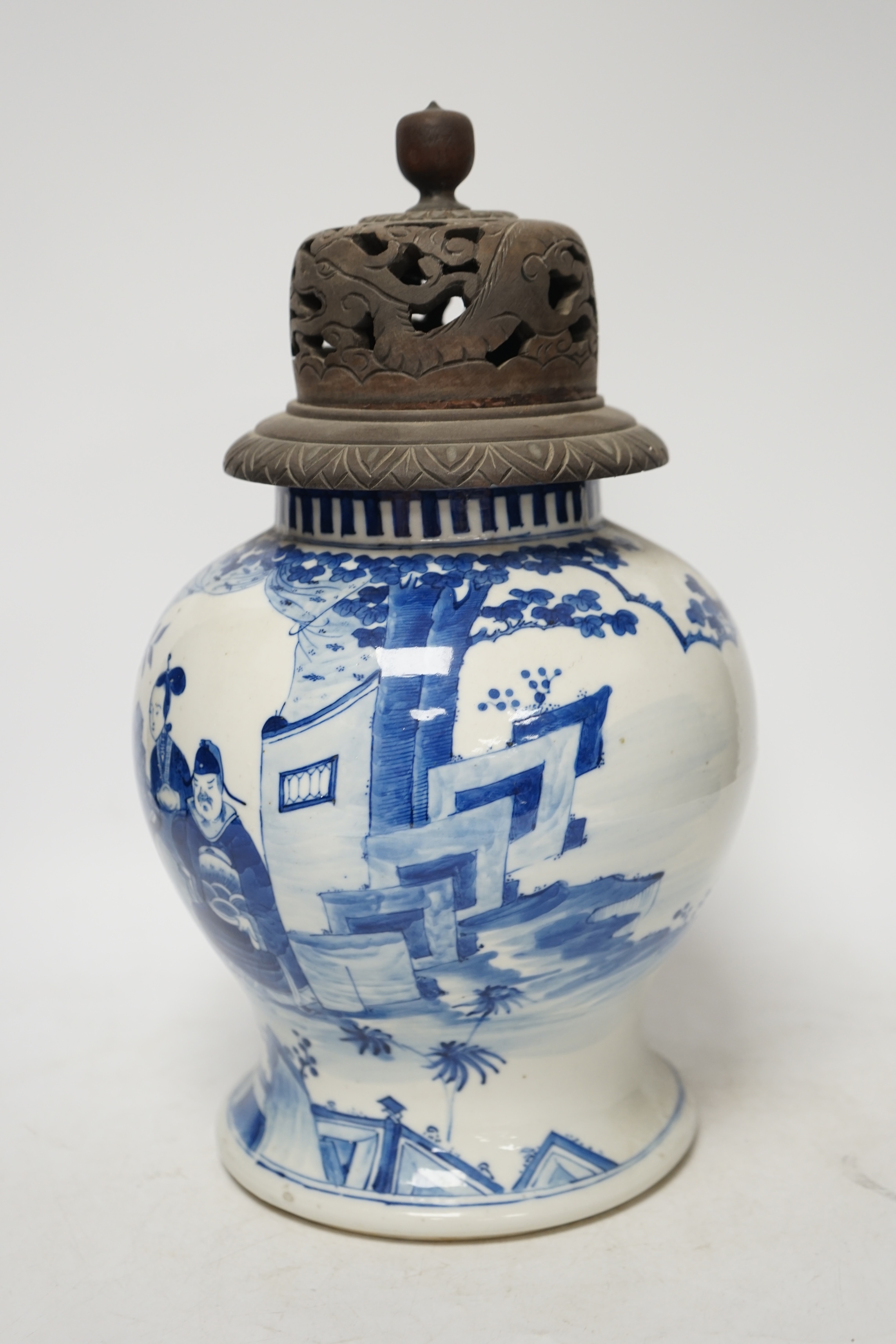A 19th century Chinese blue and white baluster jar, painted with a dignitary and attendants at a table with objects in a garden setting, wood cover, 35cm. Condition - good